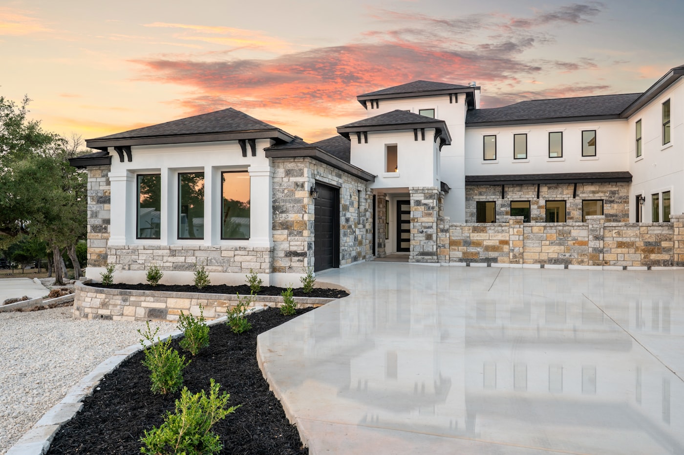 Luxury home with stone accents at sunset